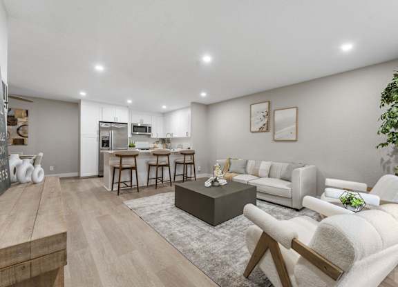 A modern living room with a kitchen in the background at Tamarack Sands Apartment Homes, Carlsbad, CA