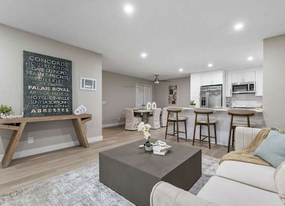 A living room with a coffee table and a chalkboard on the wall at Tamarack Sands Apartment Homes, Carlsbad, CA, 92008