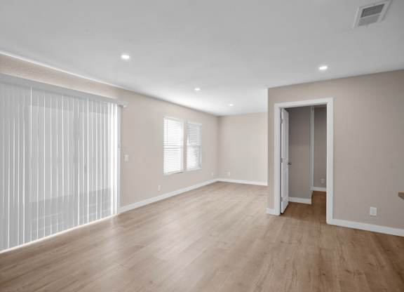 A room with a wooden floor and a sliding door.