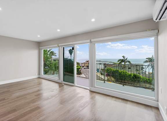 A room with a view of the ocean through large windows.
