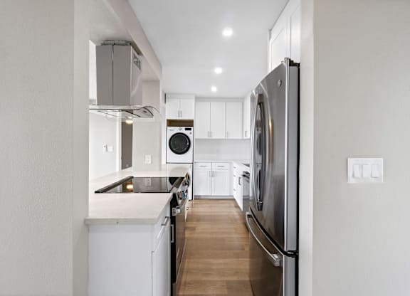 A modern kitchen with a refrigerator on the right side.