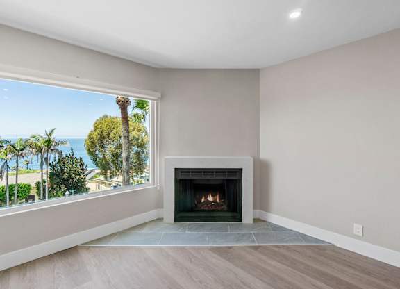 A modern living room with a fireplace and a view of the ocean.