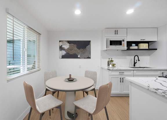 A kitchen with a table and chairs.