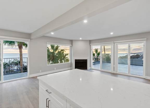 A spacious living room with a fireplace and sliding glass doors.at Ocean Edge @ Laguna Beach, California