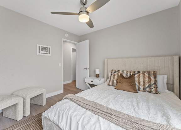 A bedroom with a bed, pillows, and a ceiling fan at Tamarack Sands Apartment Homes, Carlsbad, CA, 92008