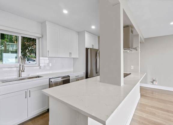 A modern kitchen with white cabinets and a large island.