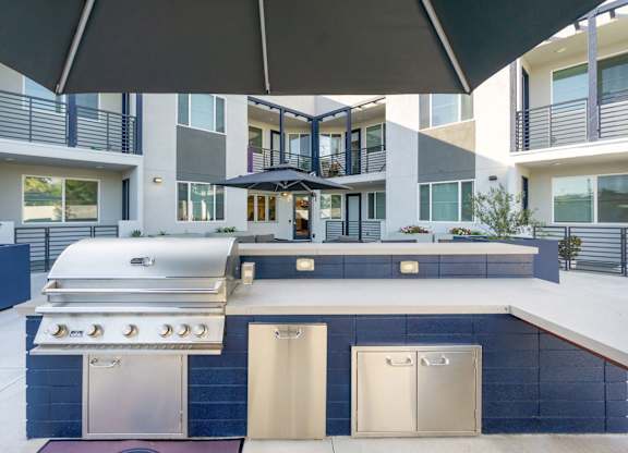 A modern outdoor kitchen with a grill and sink. at The Reserve La Mirada, La Mirada, California