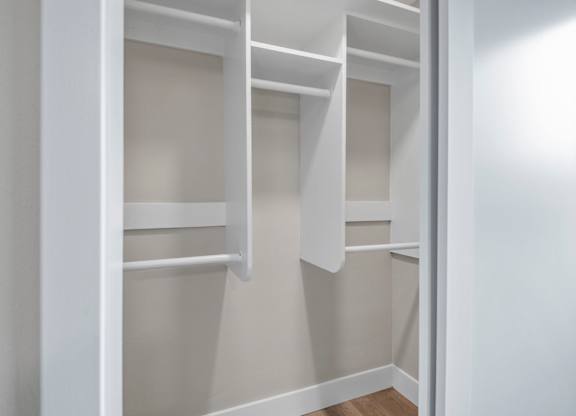 A white closet with shelves and a door open.