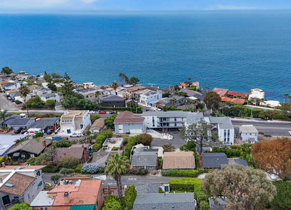 A coastal residential area with houses and a view of the ocean.