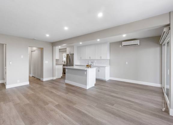A spacious kitchen with a bar area and a dining table.