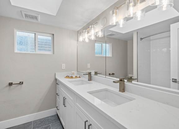 A bathroom with a large mirror and a window.
