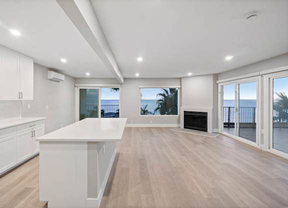 A spacious kitchen with white cabinets and a large island.at Ocean Edge @ Laguna Beach, Laguna Beach California