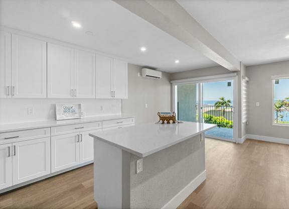 A kitchen with white cabinets and a large island.