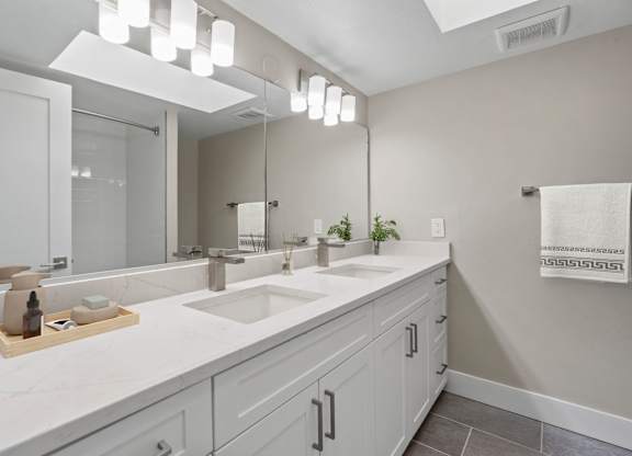 A bathroom with a white counter top and a large mirror.at Ocean Edge @ Laguna Beach, California, 92651