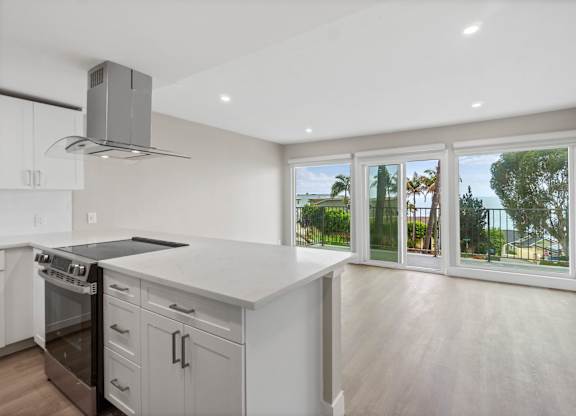 A modern kitchen with a stainless steel oven and a marble countertop.