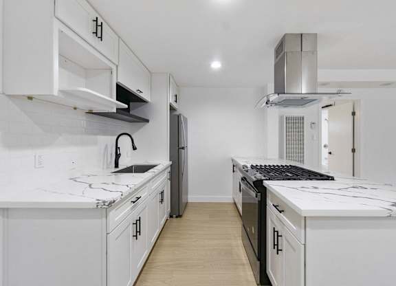A white kitchen with a black stove top oven. at Torrance Gateway Apartments, Torrance, 90501