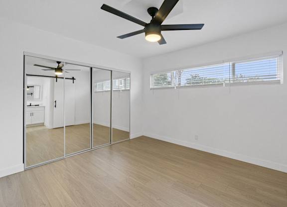 A room with a ceiling fan and a sliding glass door. at Torrance Gateway Apartments, Torrance, CA