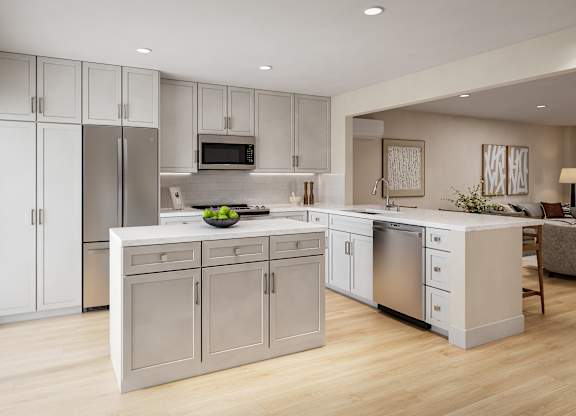 A modern kitchen with a refrigerator, microwave, oven, and sink.