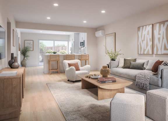 A modern living room with a grey sofa, wooden coffee table, and a large window.
