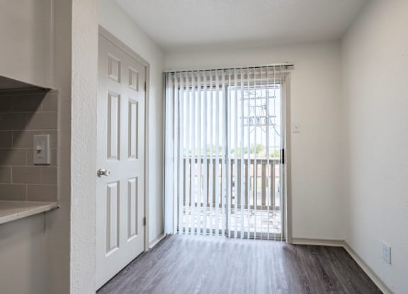 an empty living room with a door to a balcony