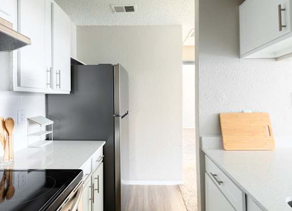 A kitchen with a black fridge and white cabinets. at Leander, Texas, 76109
