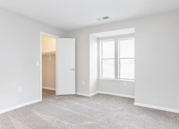 an empty room with a window and a closet