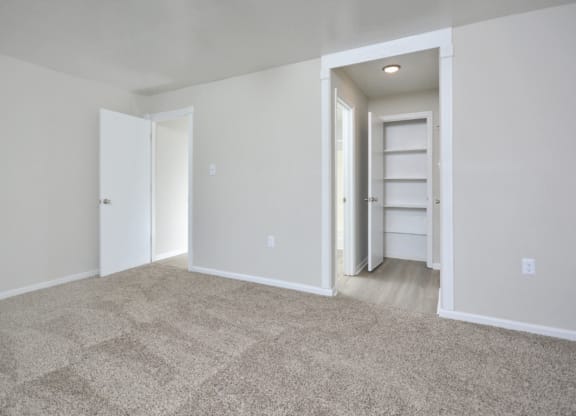 an empty living room with white walls and carpet