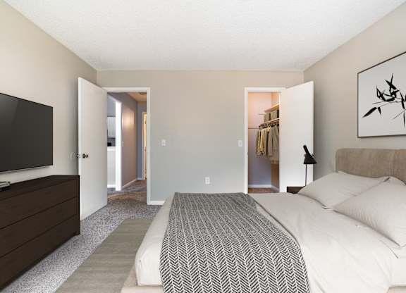 A bedroom with a large bed and a television.