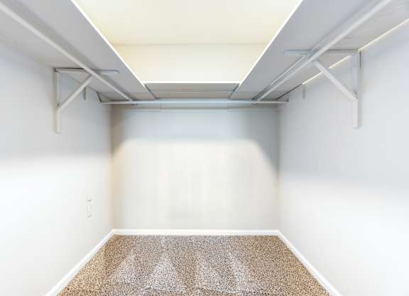 A room with a carpet and a white wall.