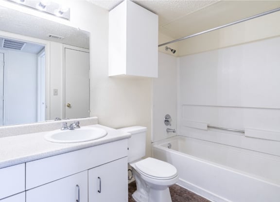 A white bathroom with a toilet, sink, and bathtub.