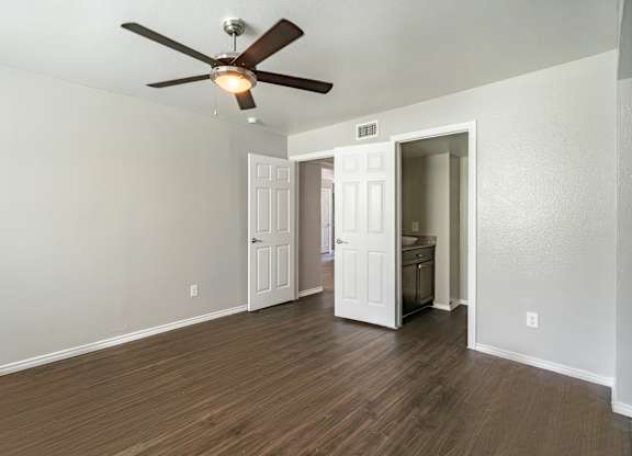 Empty bedroom with ceiling fan and hardwood flooring at Lumina Apartments, Dallas, Texas