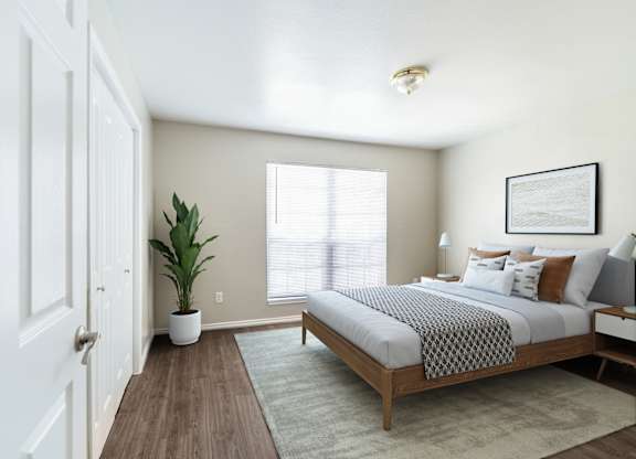 Bright bedroom with platform bed and plant at Lumina Apartments, Dallas, TX 75240