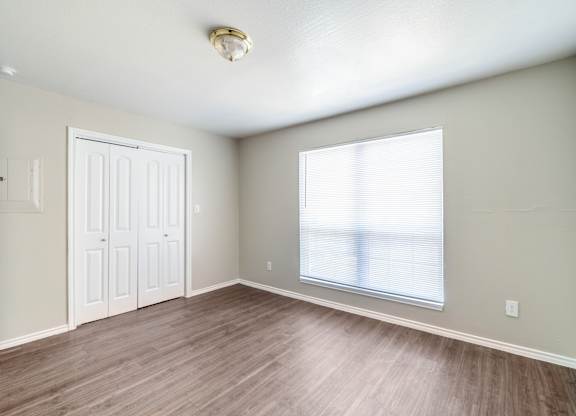 Spacious bedroom with large window and laminate floors at Lumina Apartments, Dallas, 75240