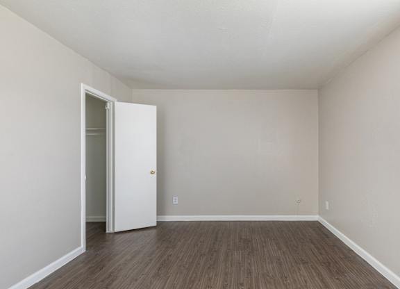 A room with a white door and wooden flooring. at Carisma, Dallas, TX, 75240