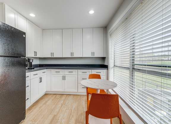 A kitchen with white cabinets and a black fridge. at Carisma, Texas, 75240
