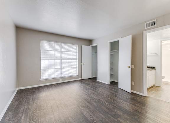 A room with a window and wooden floors.at Carisma, Dallas, TX