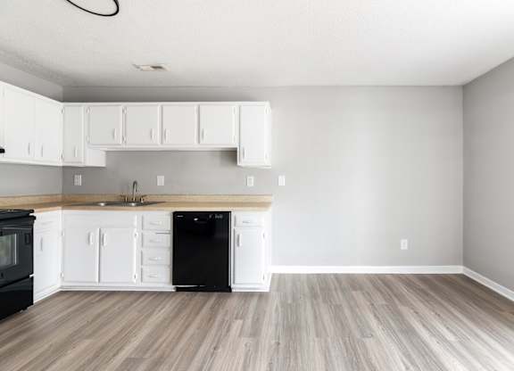 A kitchen with black appliances and white cabinets.at Lauradale, North Carolina