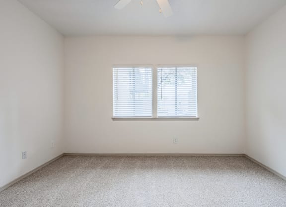 an empty room with white walls and a window