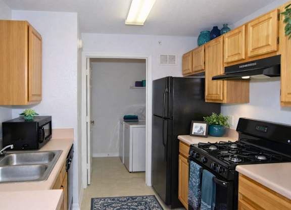 A kitchen with a black stove top oven and a black microwave.