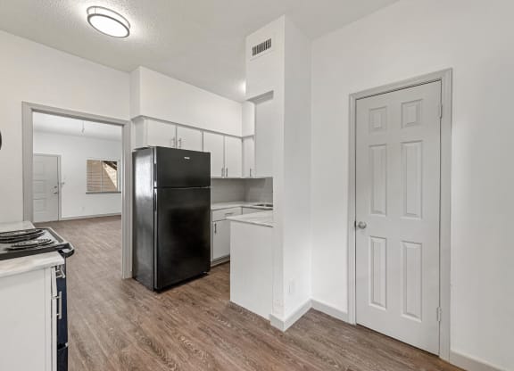 an open kitchen and living room with a refrigerator and