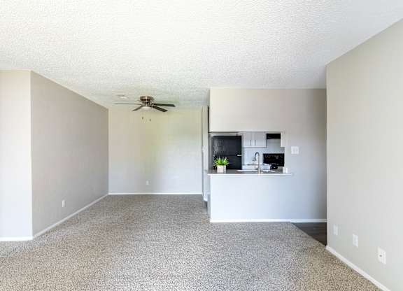 A room with a ceiling fan and a small kitchenette. at Leander, Benbrook
