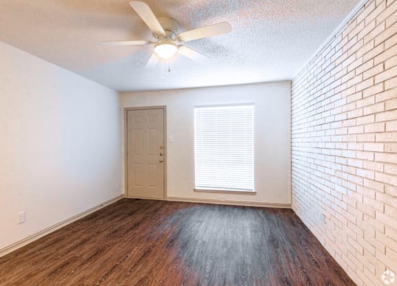 an empty room with hardwood floors and a ceiling fan