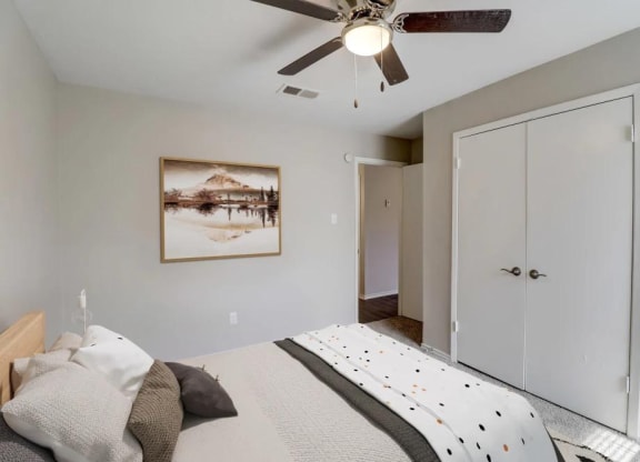 a bedroom with a bed and a ceiling fan