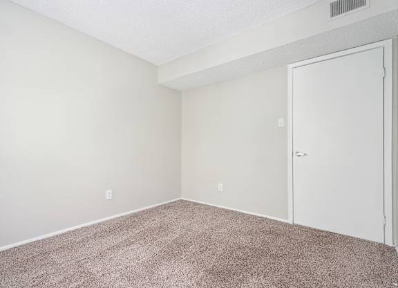 A room with a carpeted floor and a white door. at Anson at North Hills, North Carolina, 27604