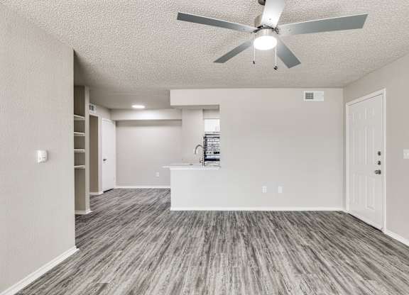 A room with a ceiling fan and a white counter.