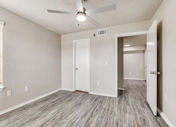 A room with a ceiling fan and two doors.