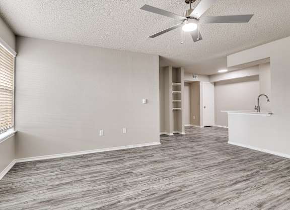 A room with a ceiling fan and wooden flooring.