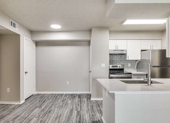 A kitchen with a sink and a refrigerator.