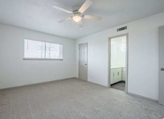the living room of an empty house with a ceiling fan