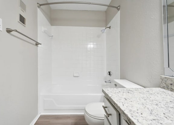A white bathroom with a toilet, sink, and shower.